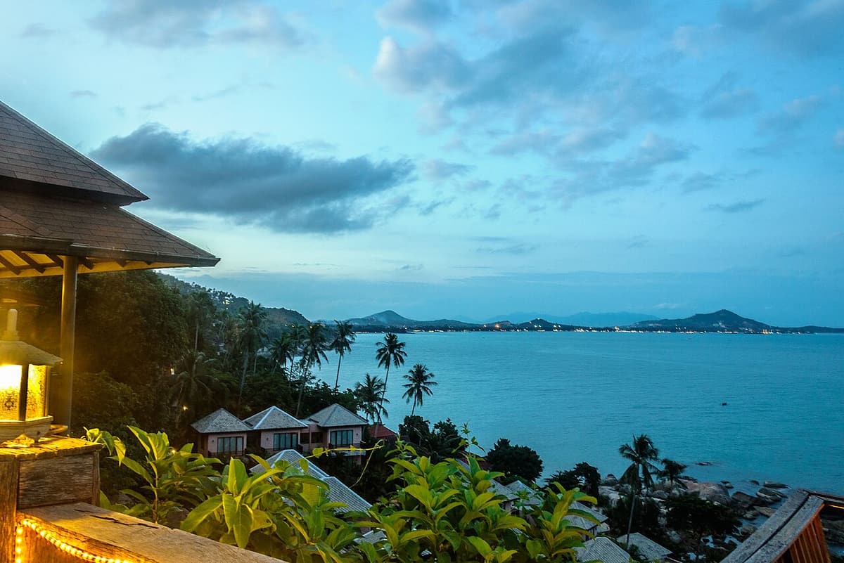 View over resort rooftops and palms to the bay at Chaweng Beach, Koh Samui