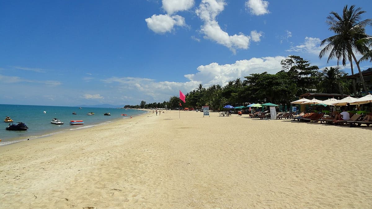 The wide sandy curve of Lamai Beach on Koh Samui on a sunny day
