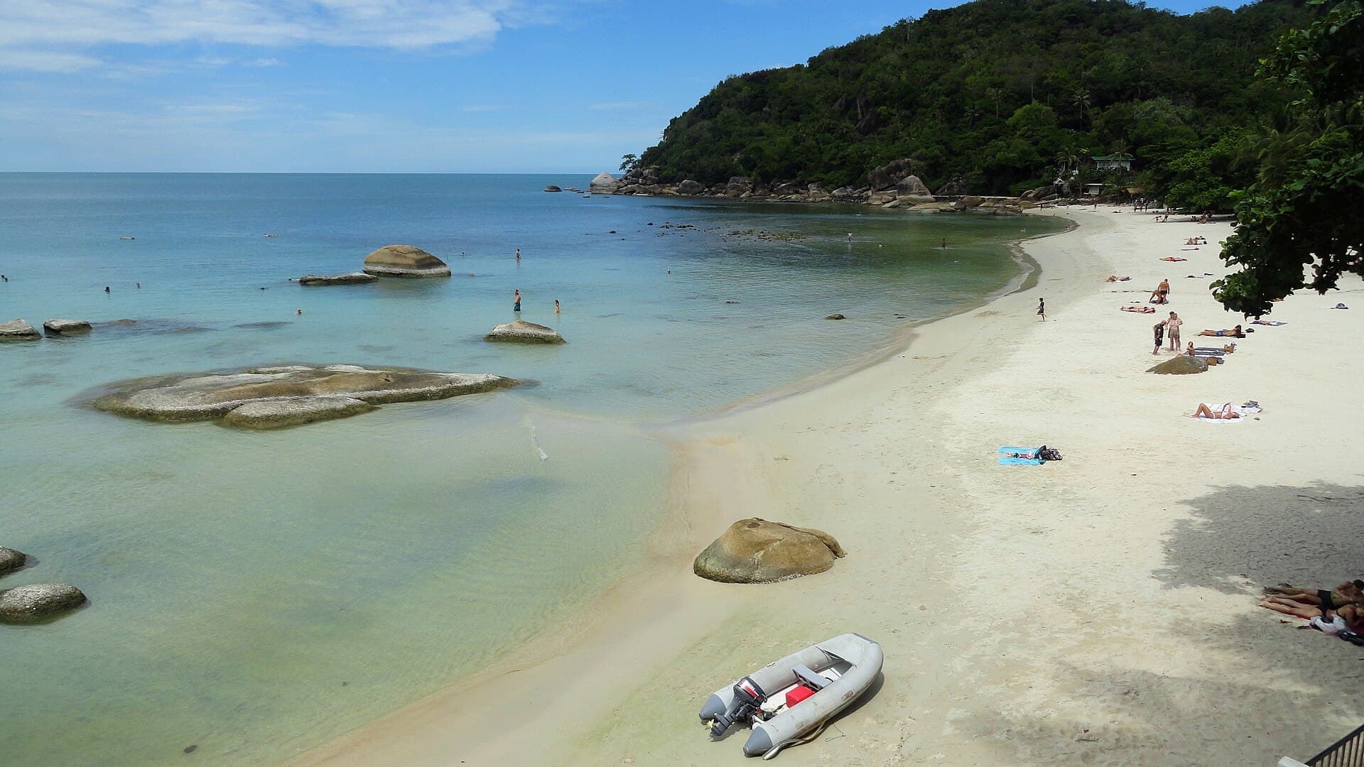 A sandy cove with granite boulders and clear turquoise water on the east coast of Koh Samui
