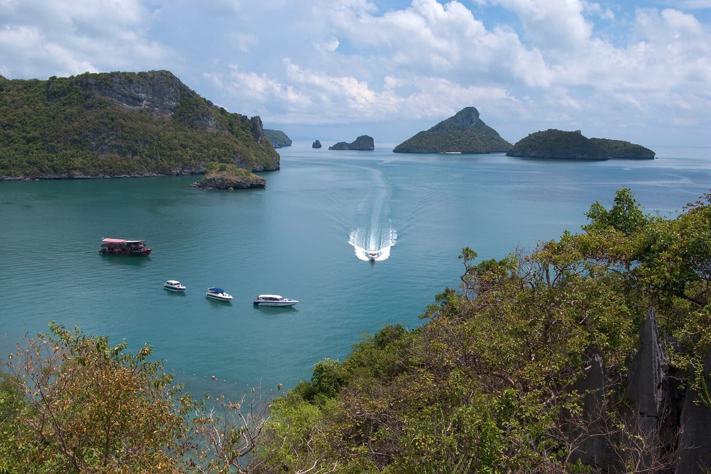 Boats anchored in a turquoise bay seen from a viewpoint in Ang Thong Marine Park